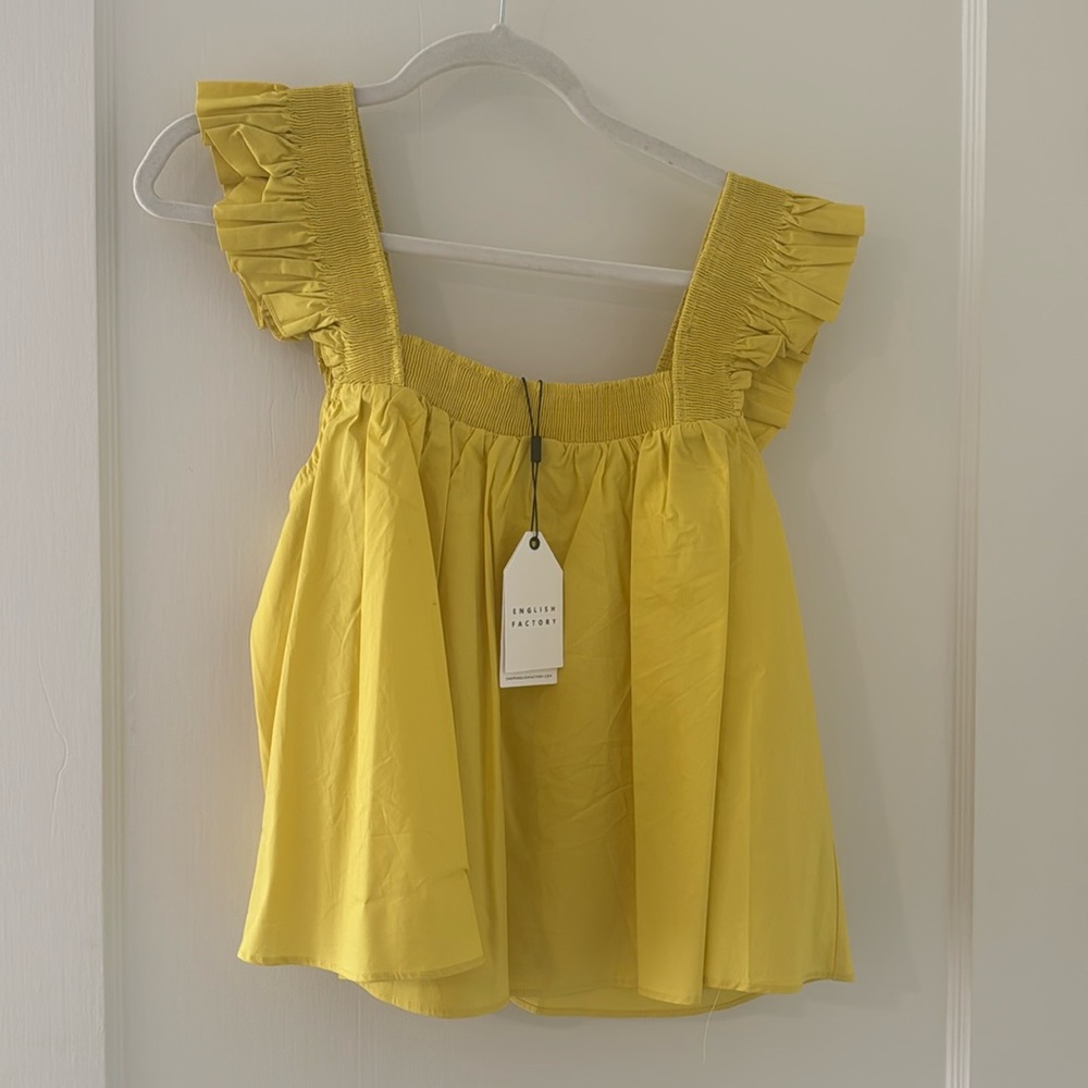 New with tags. Yellow babydoll top with ruffle sleeves